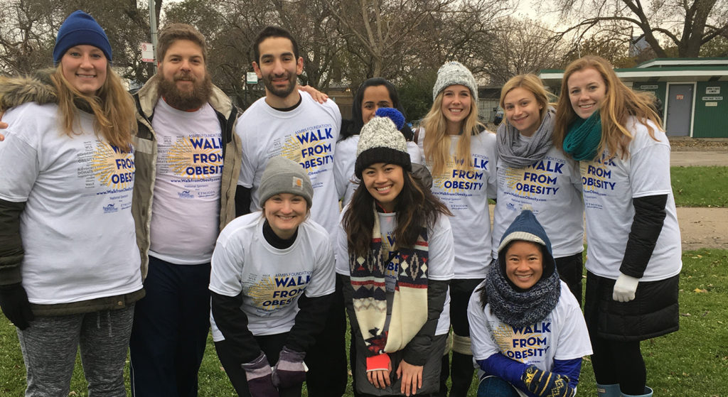 Doctor of physical therapy students and PT adjunct professor Richard Severin pose for photo wearing Walk From Obesity t-shirts