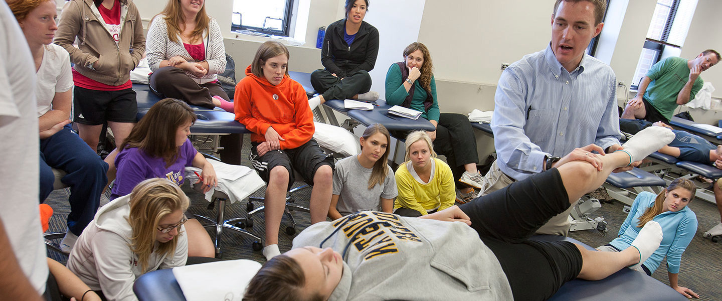 Physical therapy professor and students in a hands-on classroom