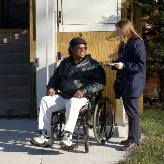 ATU staff member assisting man in wheelchair with home assessment and evaluation