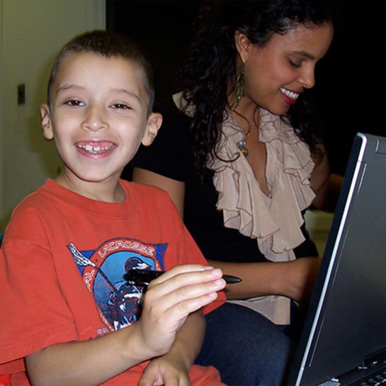 Family Clinic staff member teaching child how to work with tablet computer