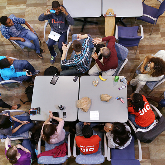 A diverse group of students hanging out around a table, viewed from above