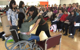 Student demonostrating how to properly lift patient from wheel chair